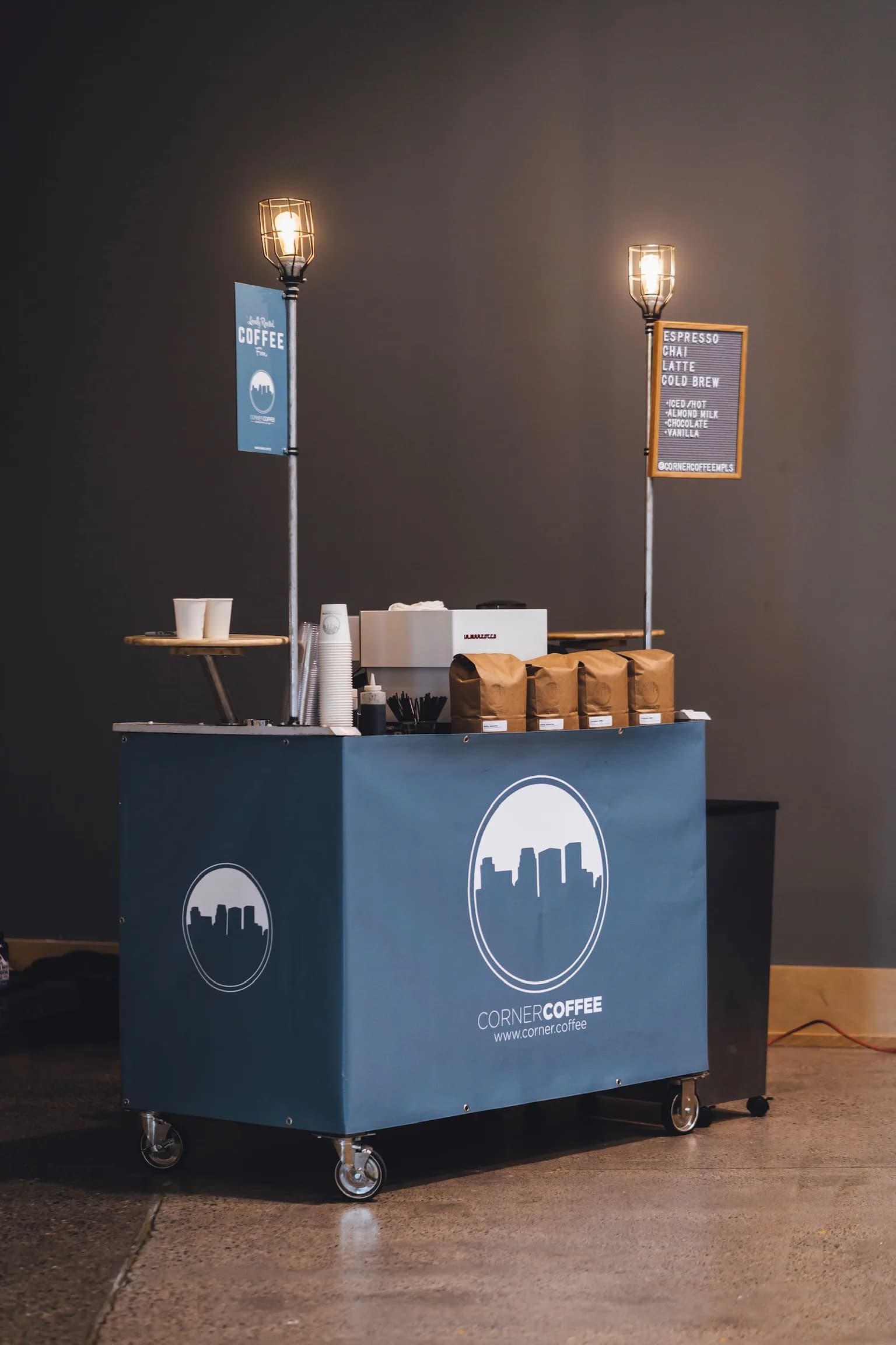 Corner Coffee branded mobile cart with lamps and menu ready for service