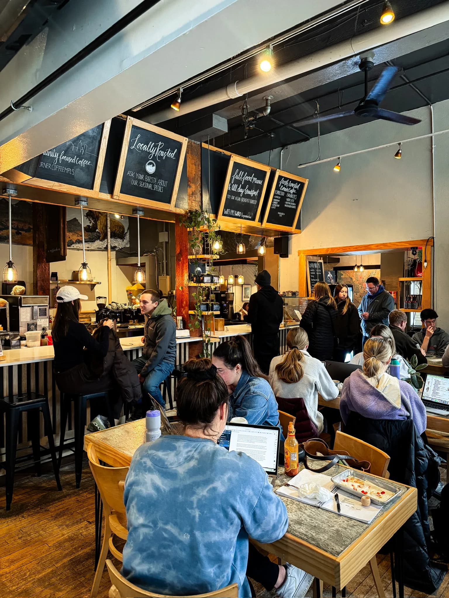 Corner Coffee North Loop cafe filled with guests below the menu boards