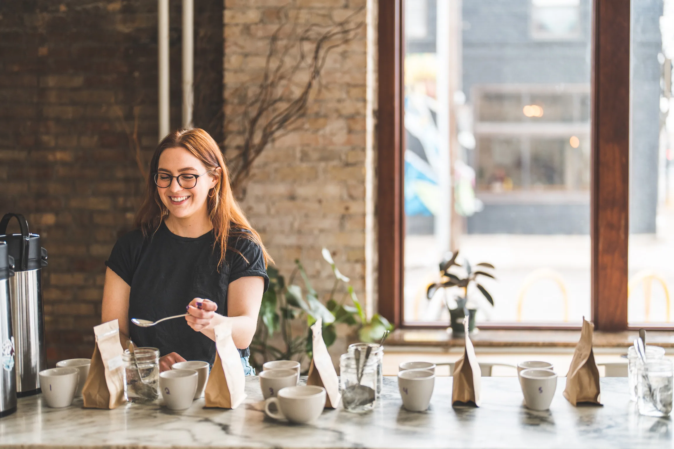Kim smiling while cupping coffees to pick the next Corner Coffee lineup