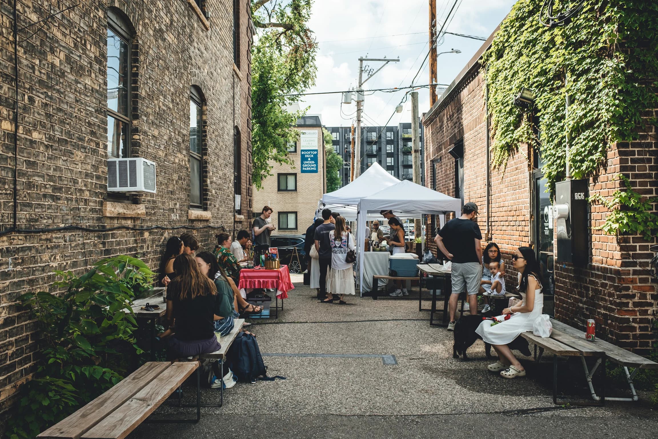 Community market gathering in the alley beside Corner Coffee Uptown