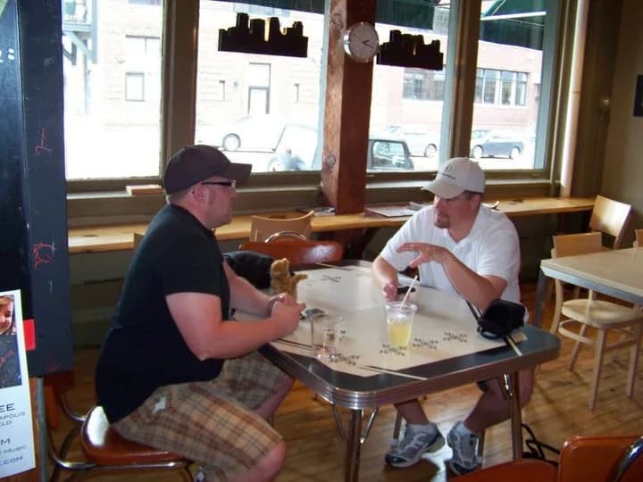 Two guests talking over drinks at the original North Loop coffeehouse